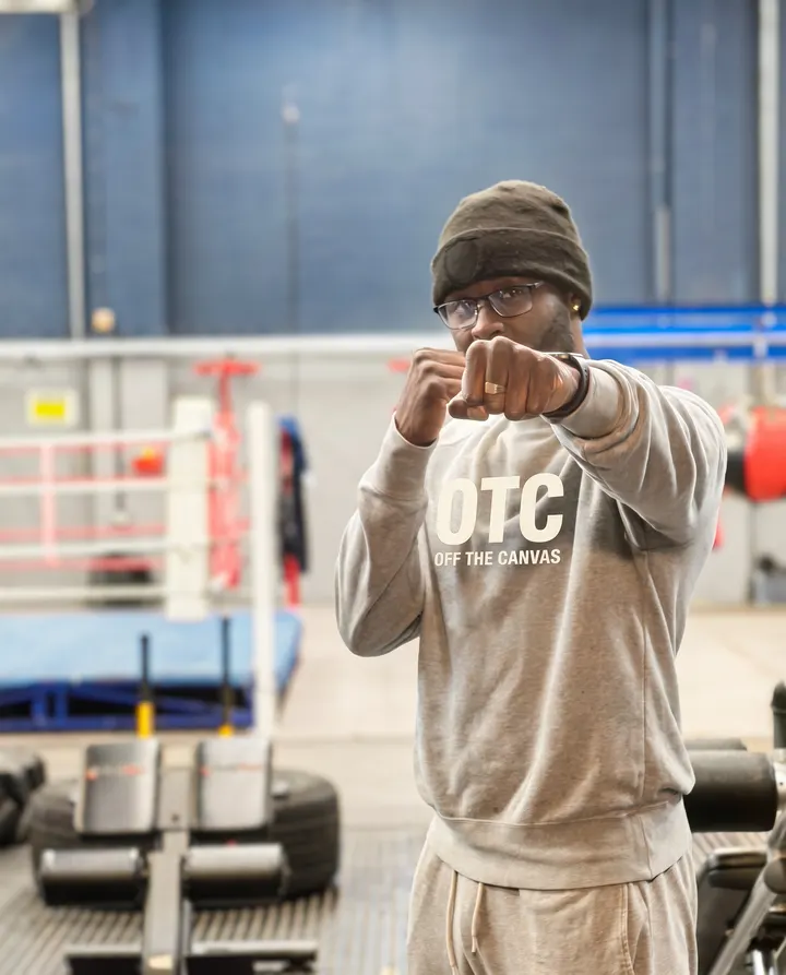 Luis Palmer, founder of Off The Canvas Boxing CIC, in a boxing stance wearing an OTC t-shirt